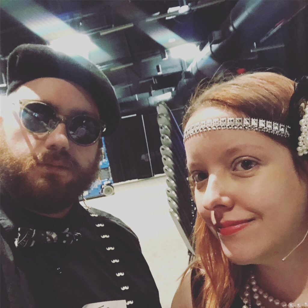 Two performers in 20s Hollywood attire for a murder mystery show.